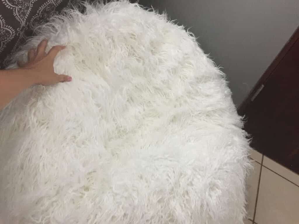 hand touching a white furry beanbag