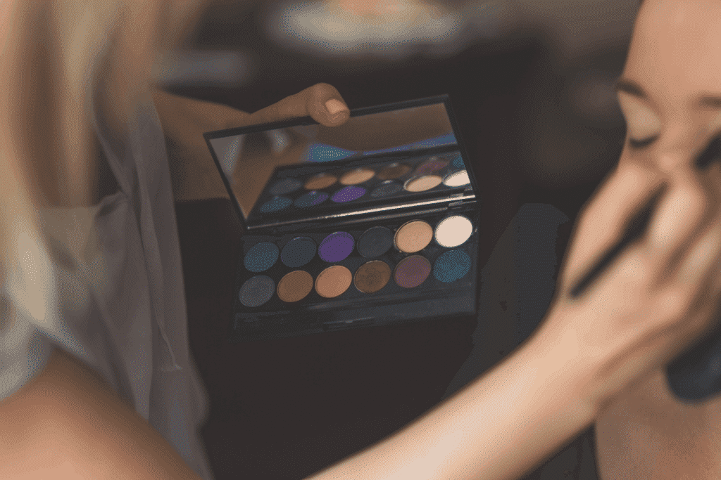 make up artist applying eyeshadow on a woman's face