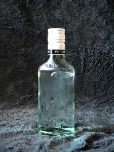 Bottle of Puerto Rican Bacardi rum photographed in a furry gray background.