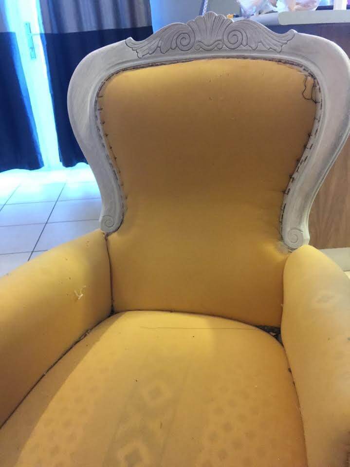 victorian arm chair with exposed foam and a white primer on its frame