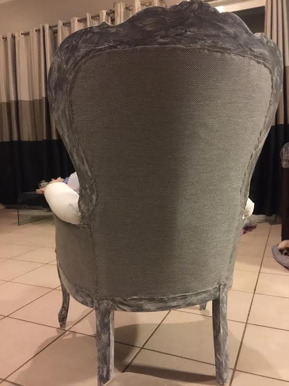 back of a victorian chair upholstered with gray fabric