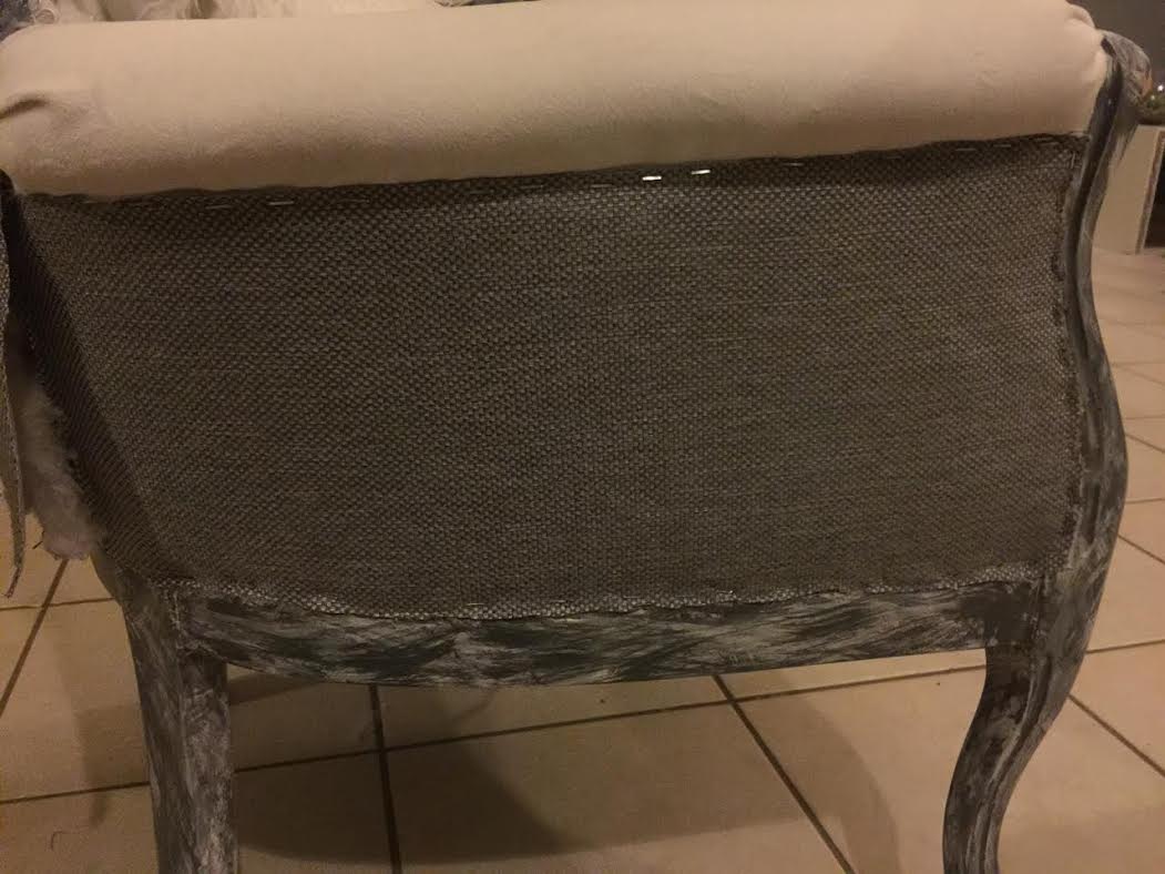 arm chair with gray fabric stapled to its outer side