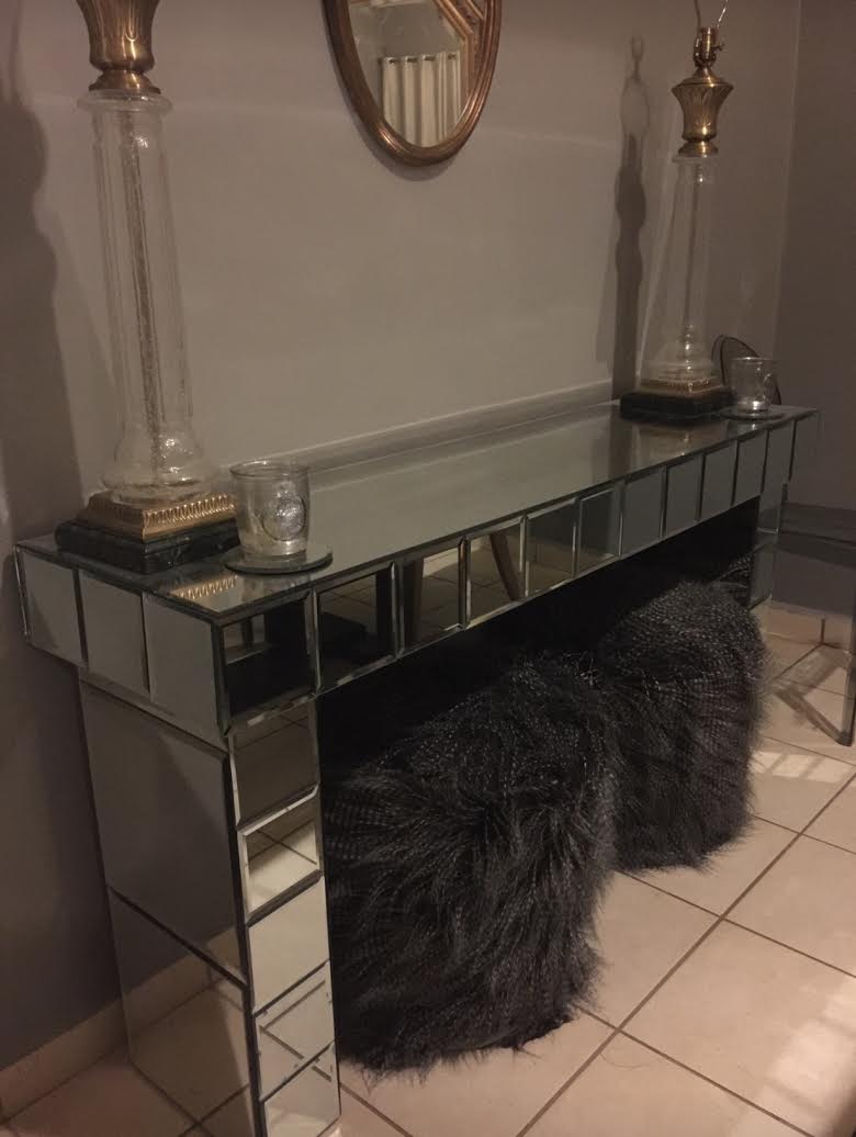 mirrored entryway table with lamps on top of it