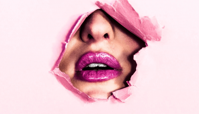 labios rosados sobresaliendo de papel rosado roto en ilustración de cuándo expira el maquillaje