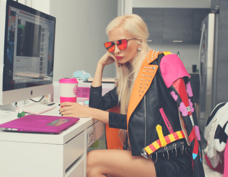 blogger sentada frente a un escritorio con taza de café en mano