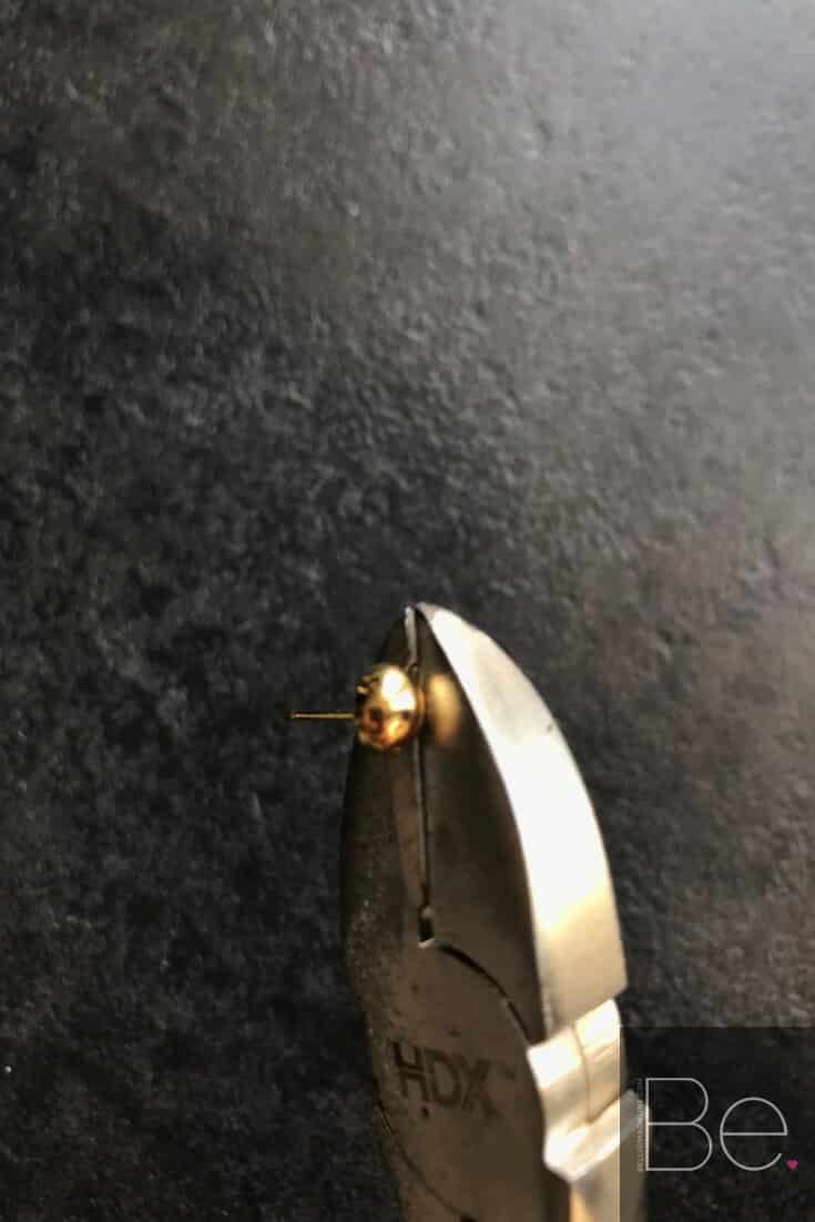 cutting pliers cutting a part of a gold earring